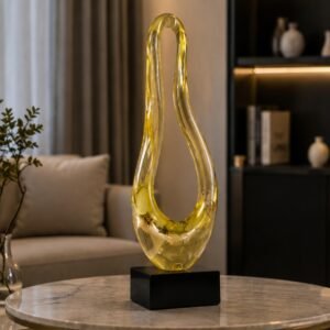 Luxury amber glass infinity sculpture with elegant fluid silhouette displayed on a black base.