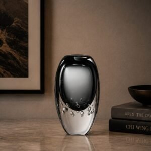 Luxury smoked black art glass vase with a crystal-clear outer layer and decorative bubble detailing, displayed as an elegant contemporary centerpiece in a sophisticated modern interior.