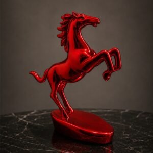 Glossy crimson red rearing horse decorative sculpture displayed on a marble surface, symbolizing strength, power, and luxury home décor.