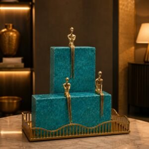 Luxury decorative sculpture set featuring three gold-tone minimalist figurines seated on crystal-inspired blocks displayed on a decorative tray.