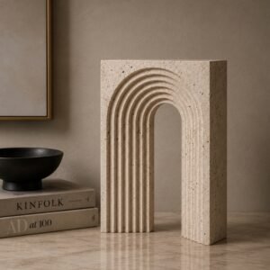 Luxury architectural arch sculpture with layered carved detailing and a natural stone-inspired finish, displayed as a contemporary decorative accent in a sophisticated modern interior.