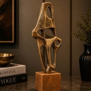 Luxury abstract bronze sculpture with an open geometric design and stone-inspired pedestal base, displayed as a contemporary decorative centerpiece in an elegant modern interior.