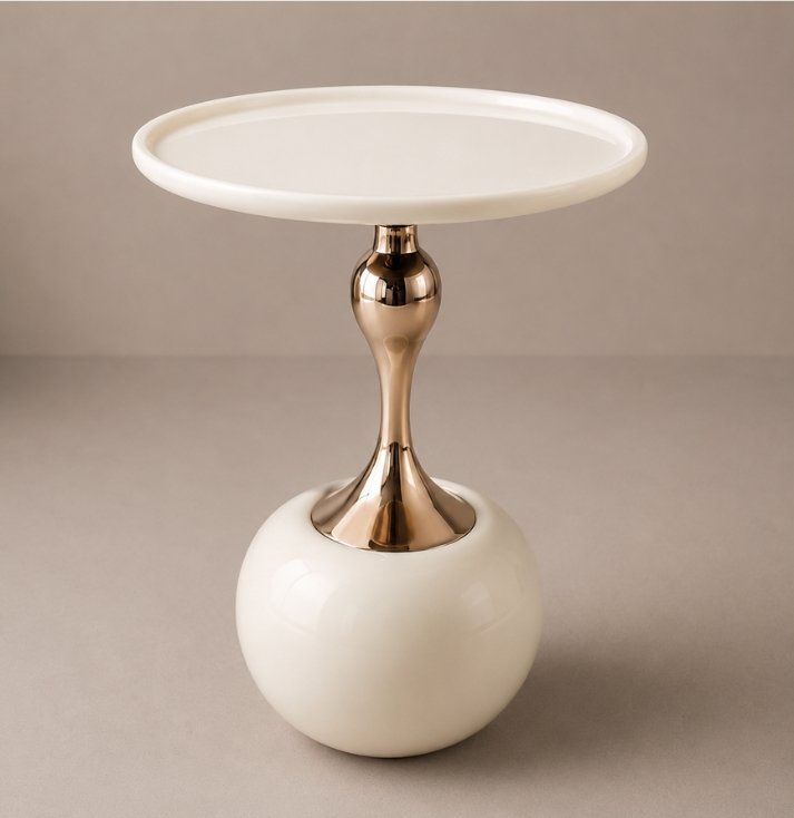 Ivory Luxe Pedestal Side Table Luxury ivory side table with round tabletop, polished gold pedestal, and sculptural spherical base.