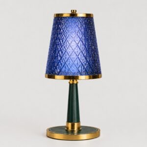 Luxury blue crystal table lamp with a geometric textured shade, gold metal accents, and an elegant green base, designed for sophisticated modern interiors.