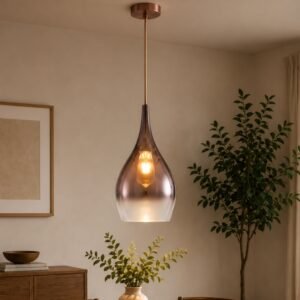 Luxury smoked glass pendant light with a tapered gradient shade, decorative filament bulb, and metallic accents, suspended in a contemporary modern interior.