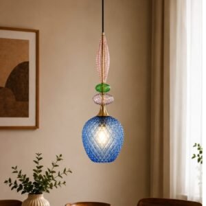 Luxury colorful art glass pendant light featuring a faceted blue glass shade, decorative pink and green glass accents, gold detailing, and warm ambient illumination in a sophisticated interior.