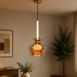 Luxury amber glass pendant light with a sculptural transparent shade, illuminated central stem, brushed gold accents, and warm ambient lighting in a contemporary interior.