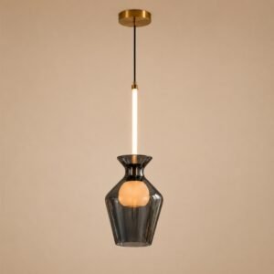 Luxury smoked glass pendant light with a sculptural faceted shade, illuminated central globe, brushed gold accents, and warm ambient lighting in a contemporary interior.