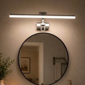 Modern LED vanity light with a sleek linear brushed metal design mounted above a round bathroom mirror, providing bright and even illumination in a contemporary interior.