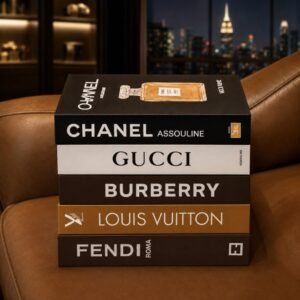 Luxury decorative fashion-inspired book box set displayed on a designer wooden bookshelf.